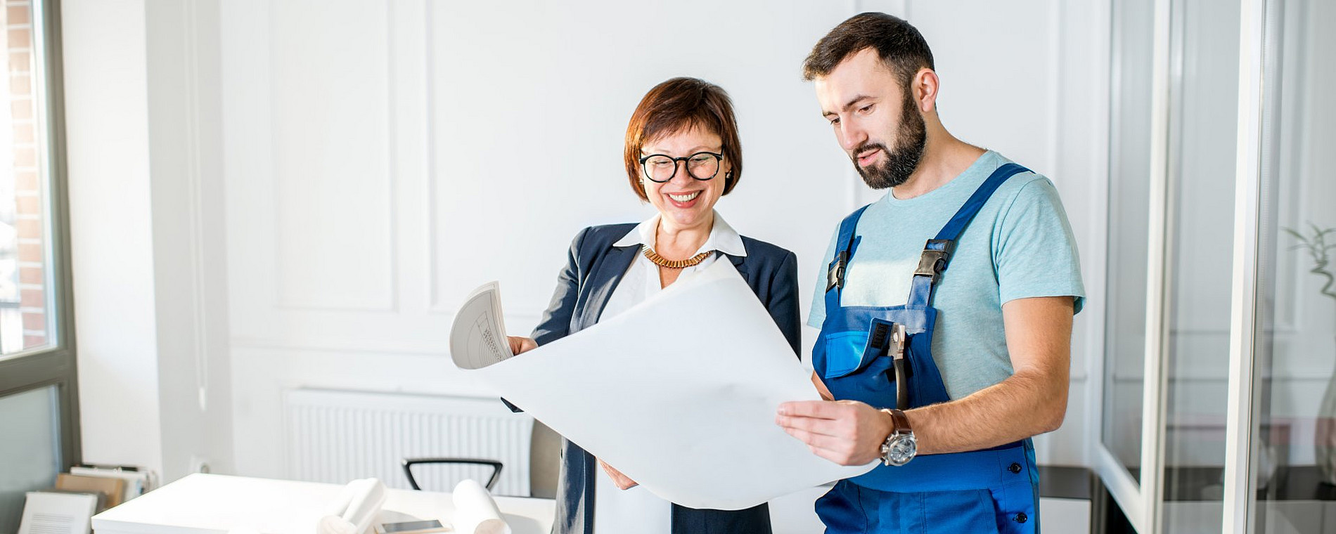 Two employees looking at a plan while working together.
